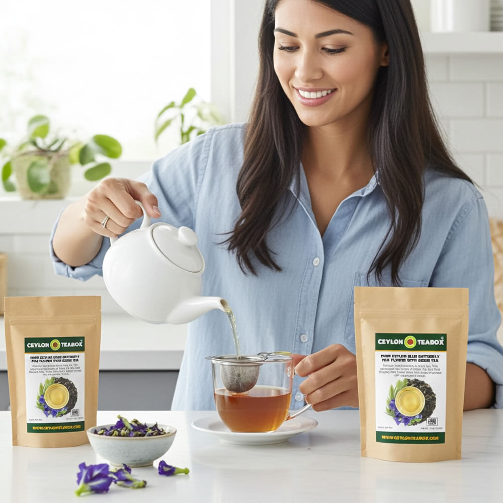 Woman pouring Pure Ceylon Blue Butterfly Pea Flower With Green Tea from a teapot into a glass cup with Ceylon Tea Box packaging in the foreground.