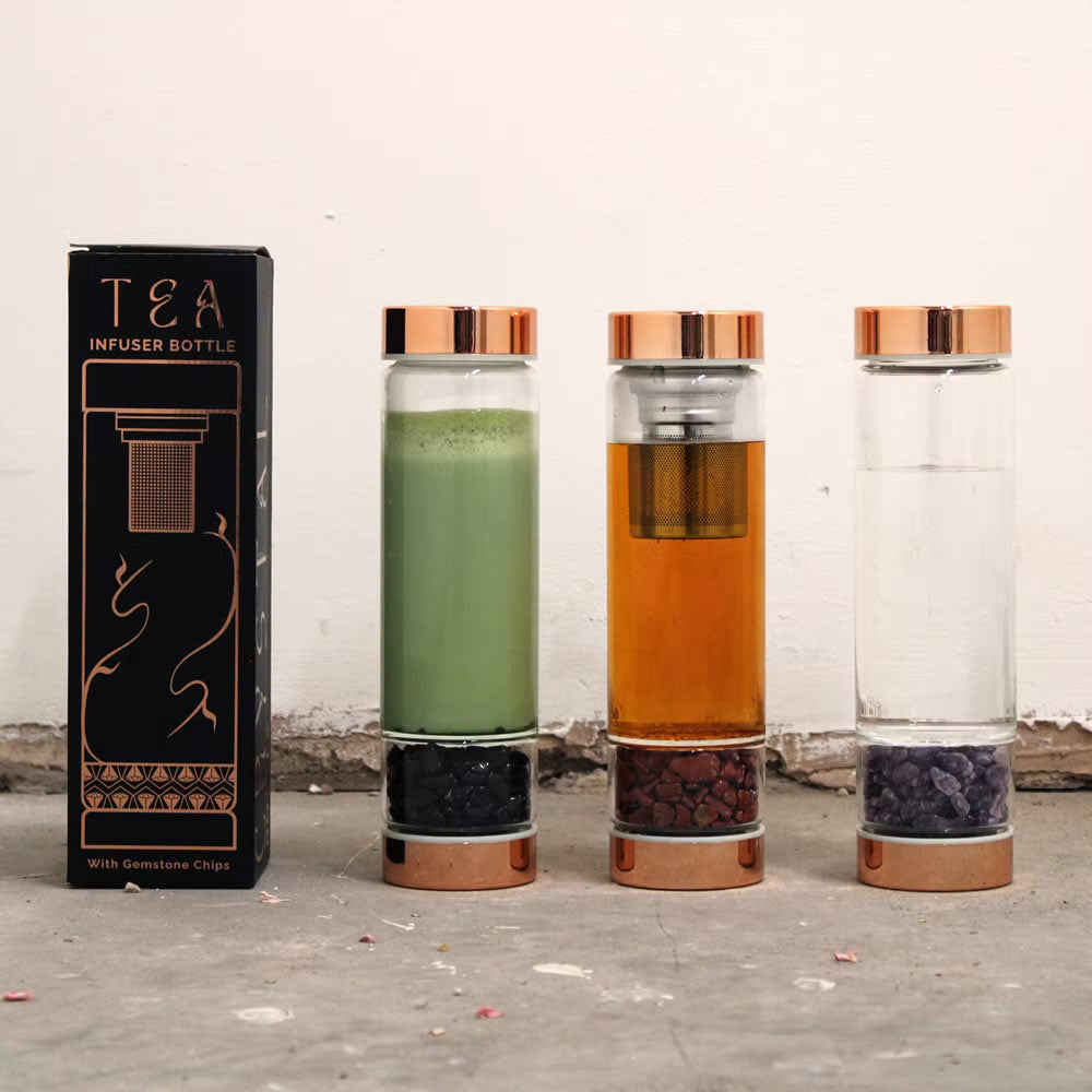 Tea infuser bottles with visible contents and packaging on a textured surface.