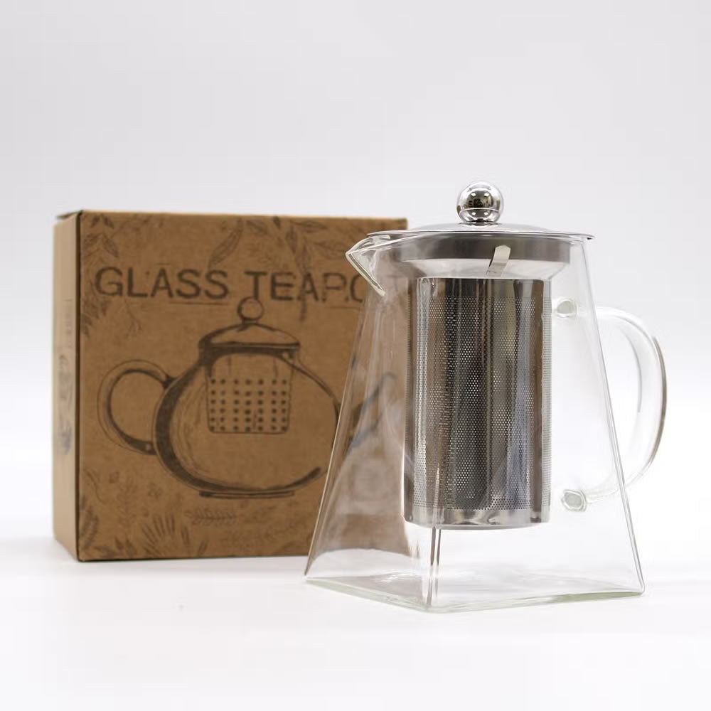 Clear glass teapot with metal infuser on a white background