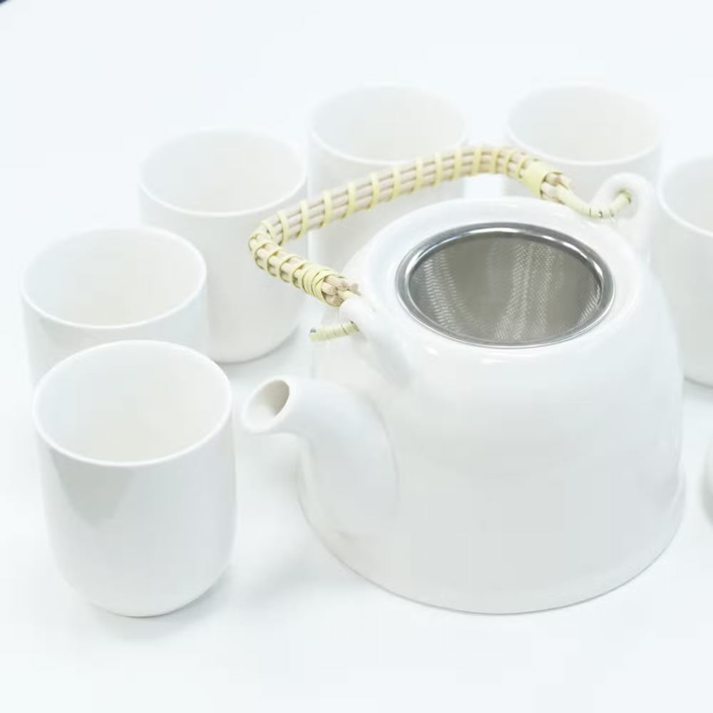 White ceramic teapot and cups on a white background