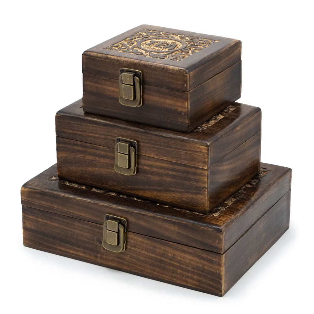 Set of three stacked wooden boxes with decorative patterns and locks on a white background