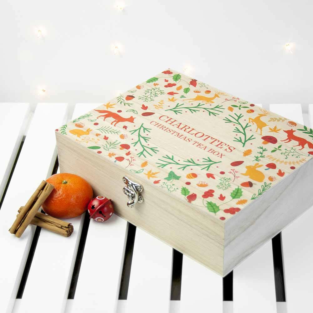 Decorative tea box with festive design on a white surface with decorative lights.