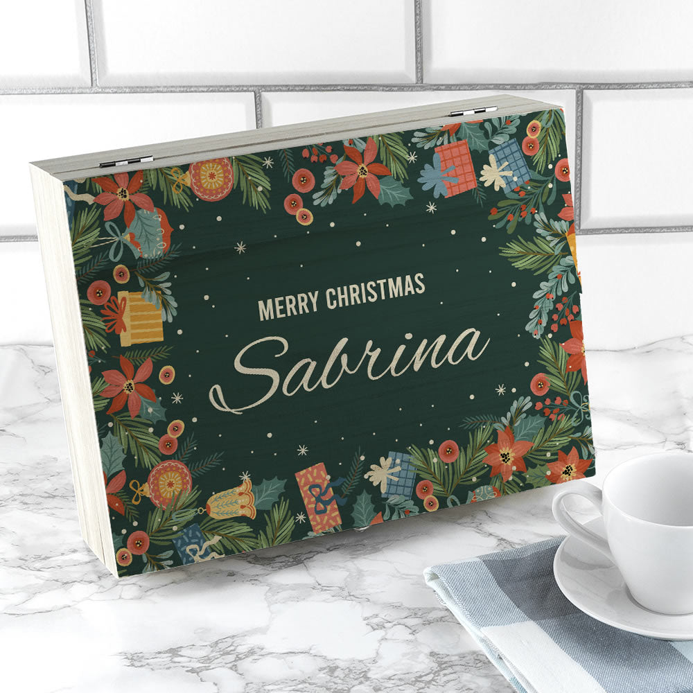 Personalised Christmas book with floral design and 'Merry Christmas Sabrina' text on a marble surface.