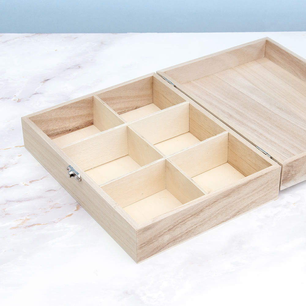 Wooden tea box with compartments on a marble surface
