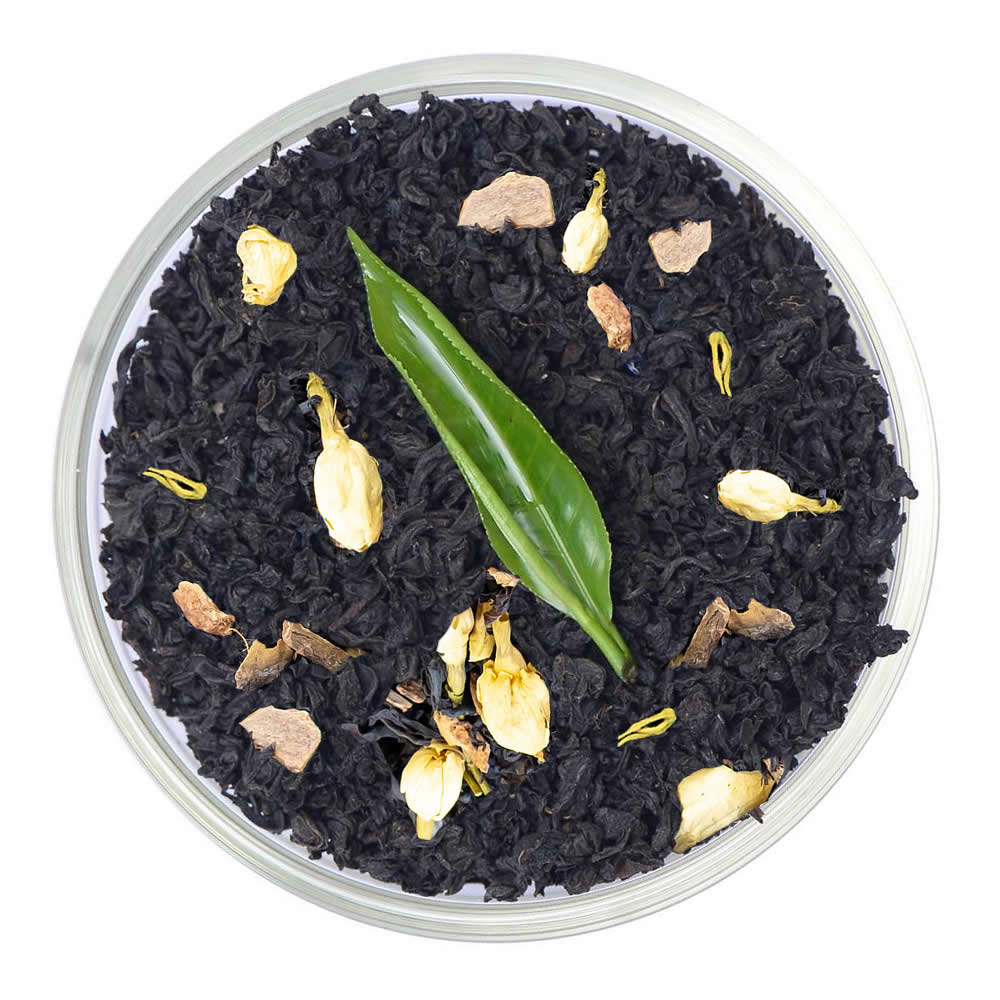 Pure Ceylon Winter Mulled Spice Tea leaves with green leaf and yellow buds in a clear container on a white background - www.ceylonteabox.com