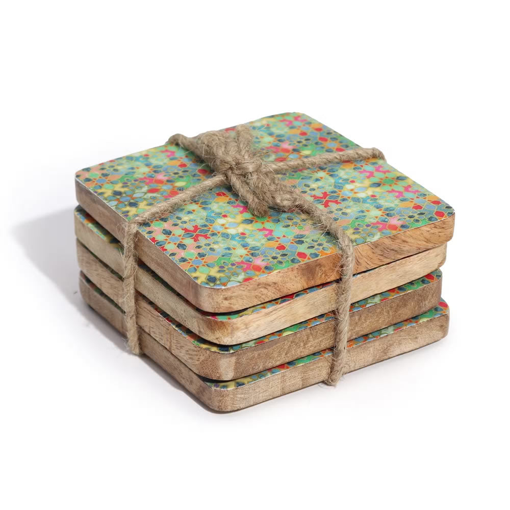 Set of four wooden coasters with colourful patterns tied together with twine on a white background