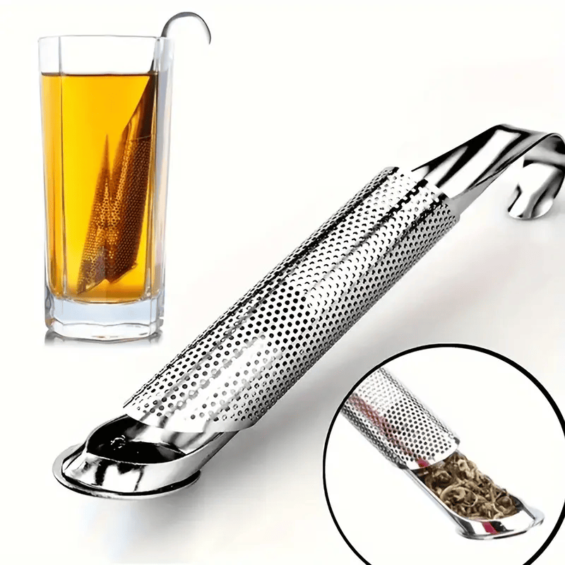 Metal tea infuser with a glass of tea in the background