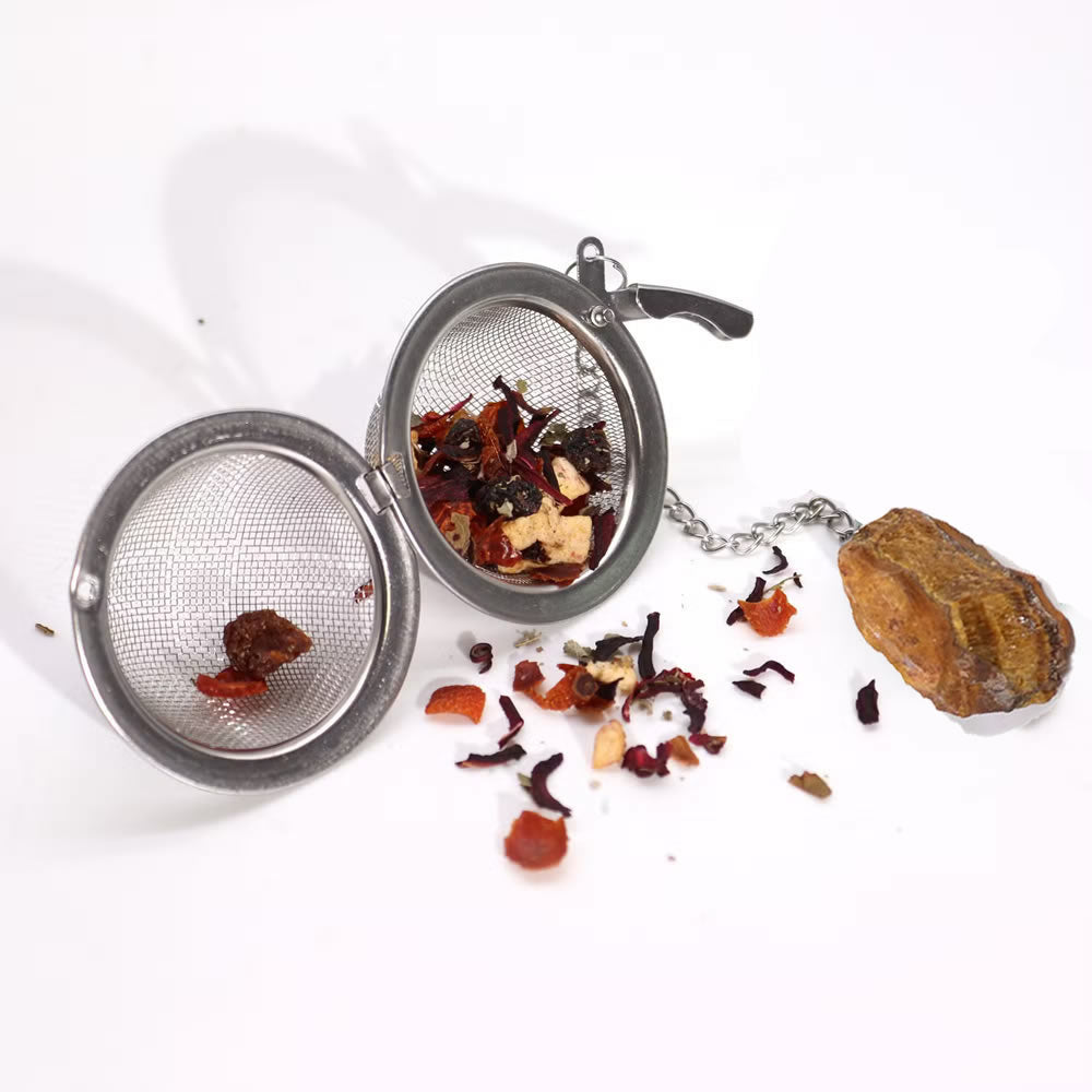 Tea infuser with dried tea leaves on a white background