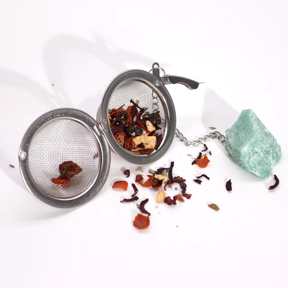 Tea infuser with loose tea leaves on a white background