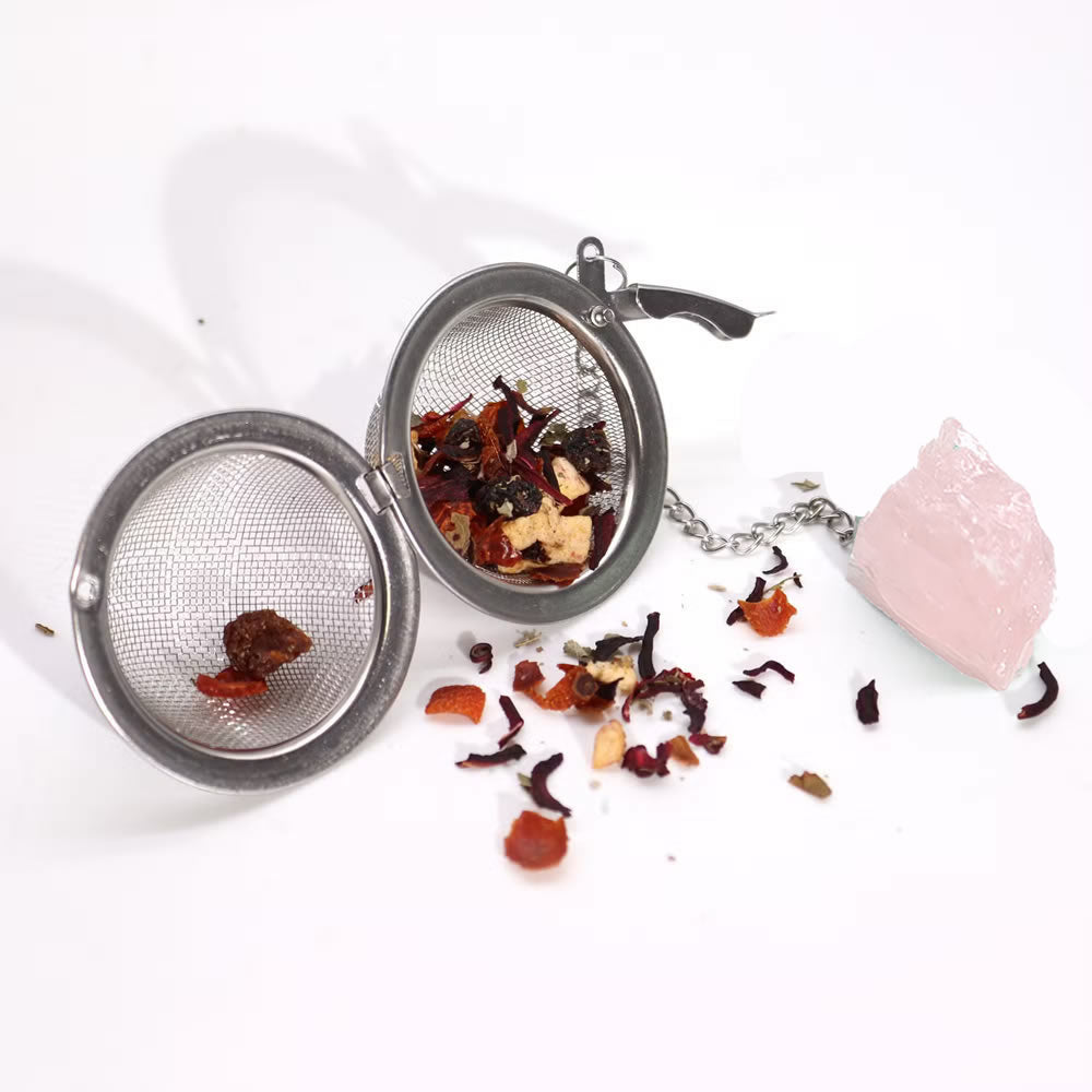 Tea infuser with loose tea leaves on a white background